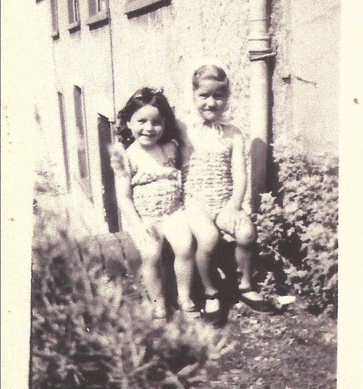Gillian Blake and Shirley Squire sitting on the wall at 50 The Rock, Pilton in 1947